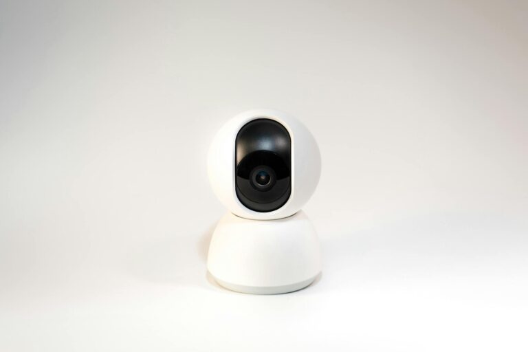 A sleek, white minimalistic smart home security camera on a white background.